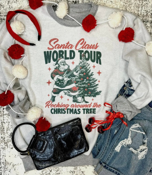 White sweatshirt with Santa Claus graphic and text, surrounded by festive decor and accessories.